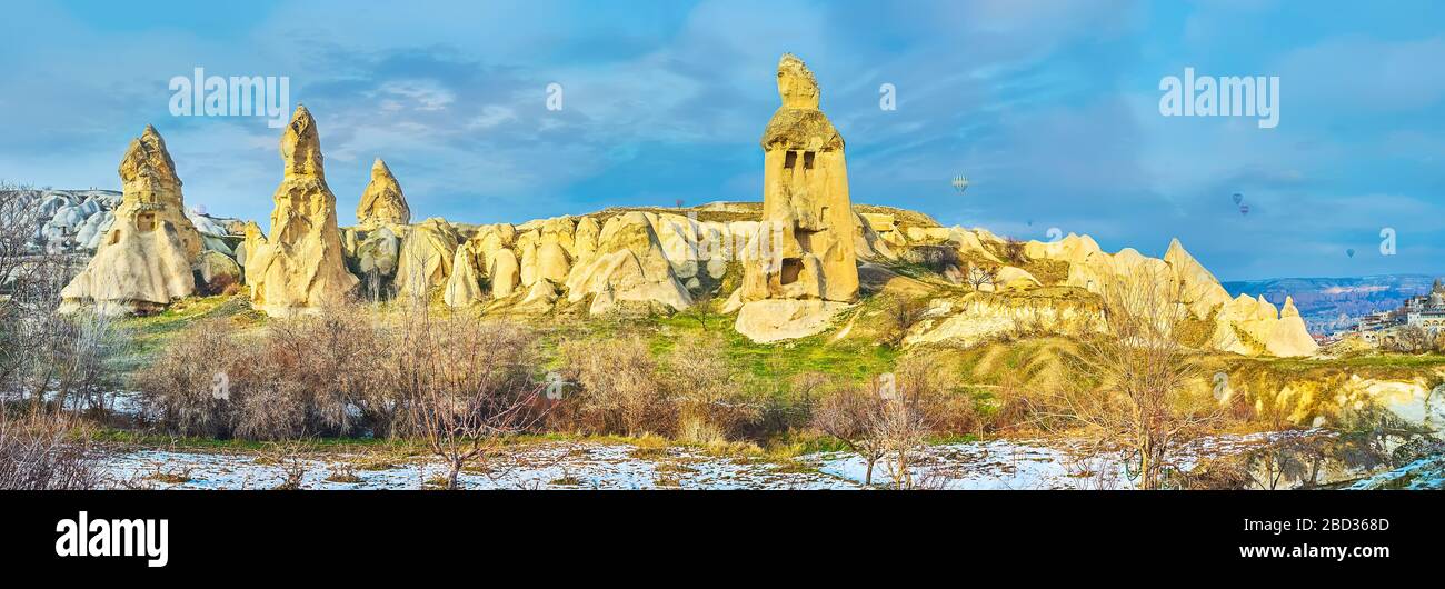 Amazing nature of Cappadocia attracts people to walk among the fairy chimney rocks, caves, tuff cliffs and old cut buildings or to fly on hot air ball Stock Photo
