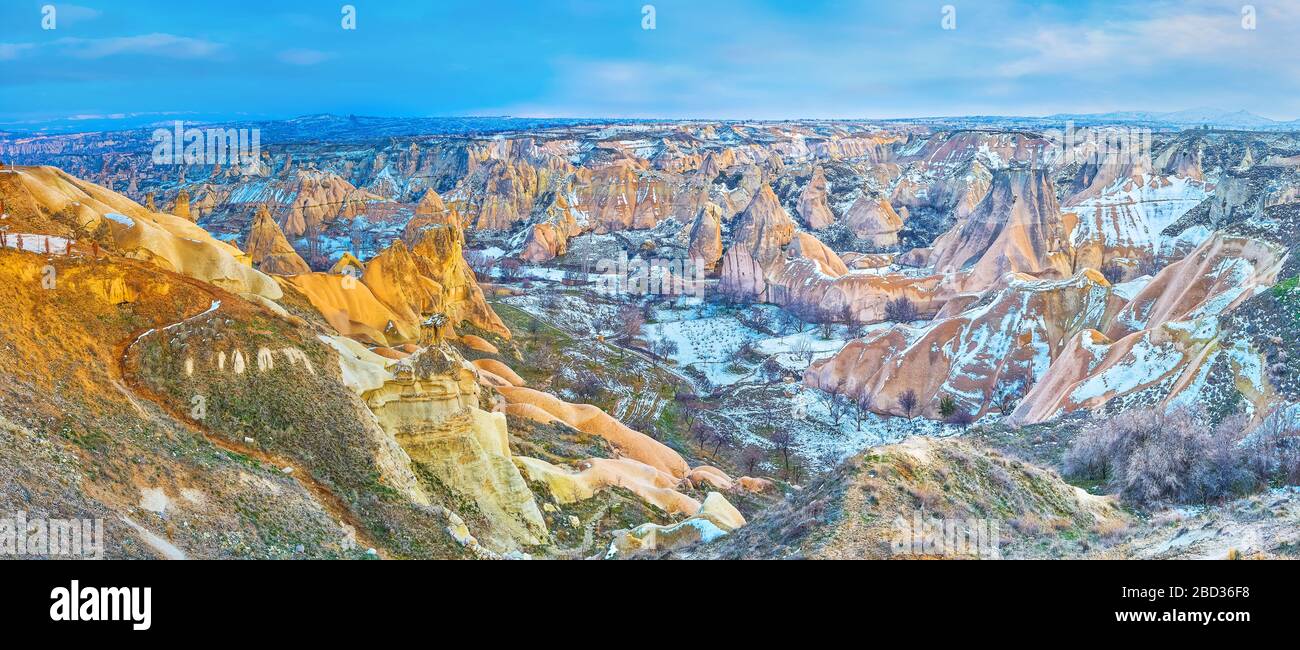 Top panorama of snowbound Pigeon Valley withyellow and orange tuff rocks and orchards among them, Cappadocia, Turkey Stock Photo