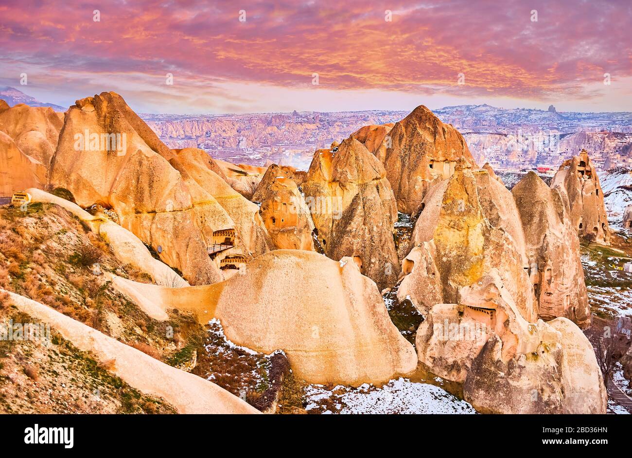 The bright orange rocks and cliffs of Cappadocia looks great in purple twilights, Turkey Stock Photo