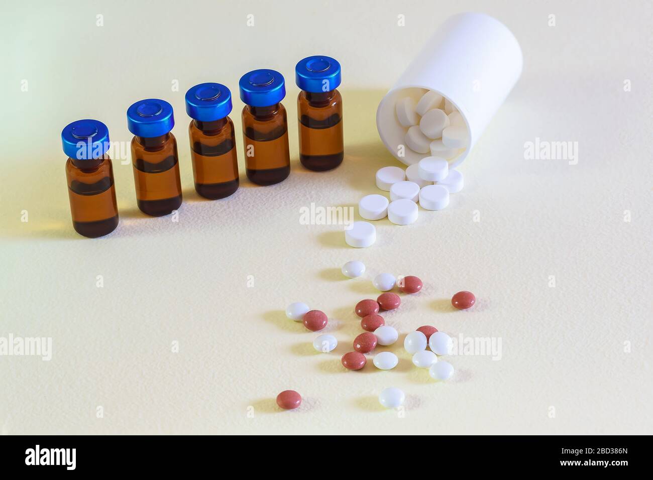 Vials of injectable drugs and scattered pills on the table. Modern