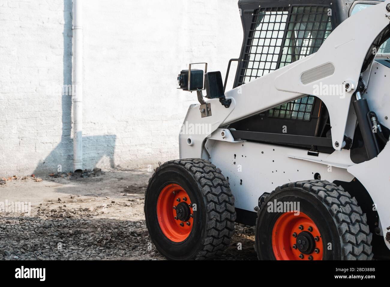 White skid steer loader at a construction site waiting of work. Industrial machinery. Industry