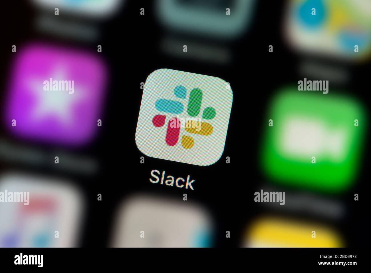A close-up shot of the Slack app icon, as seen on the screen of a smart phone (Editorial use only) Stock Photo