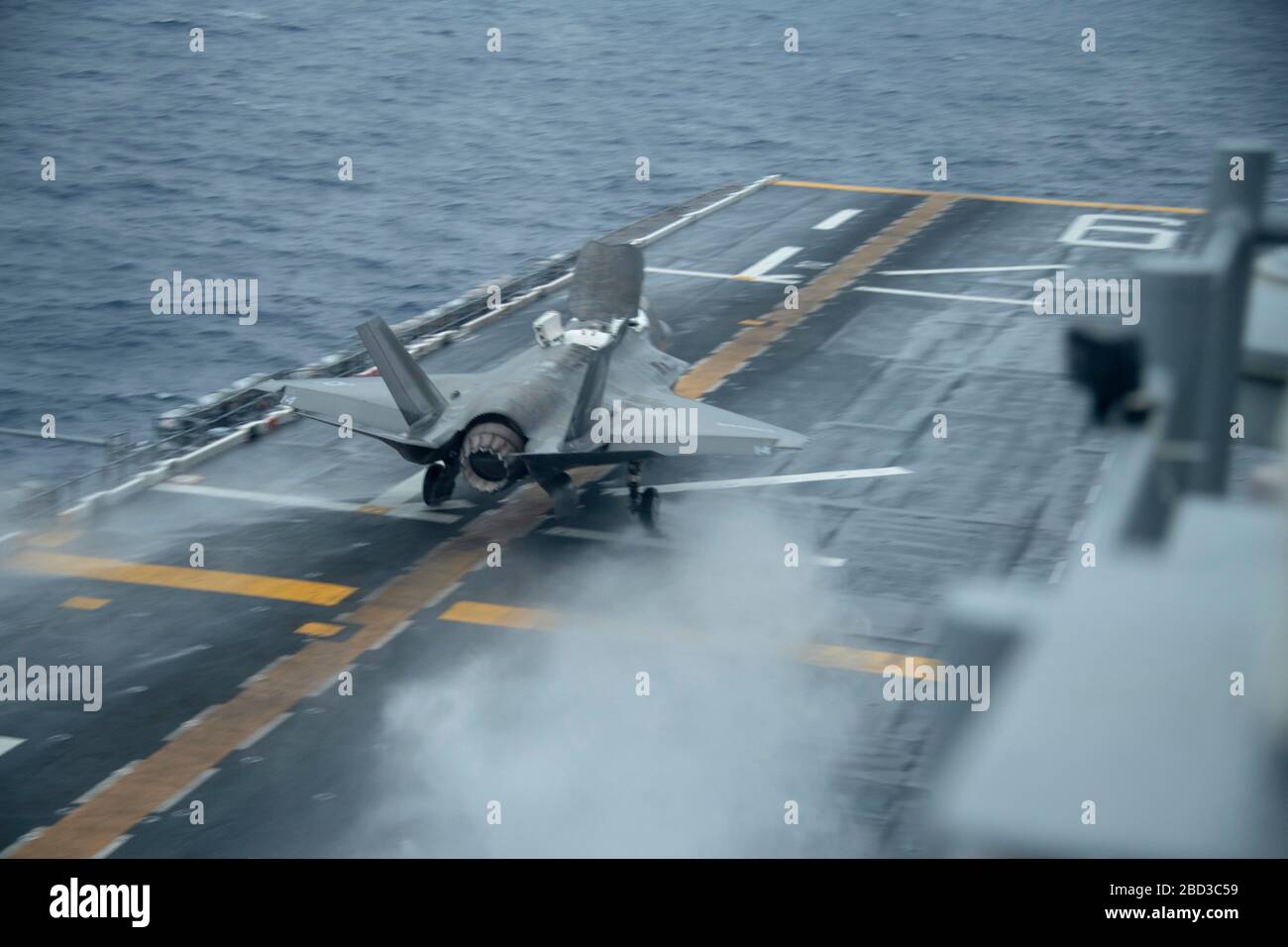 A U.S. Marine Corps F-35B Lightning II stealth fighter, assigned to the 31st Marine Expeditionary Unit, performs a vertical landing on the flight deck of the Flagship America-class amphibious assault ship USS America during routine operations April 4, 2020 in the Philippine Sea. Stock Photo