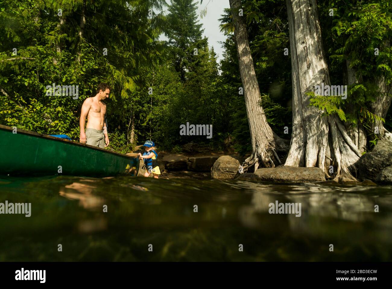 A young girl walks next to a canoe on Lost Lake in Oregon. Stock Photo