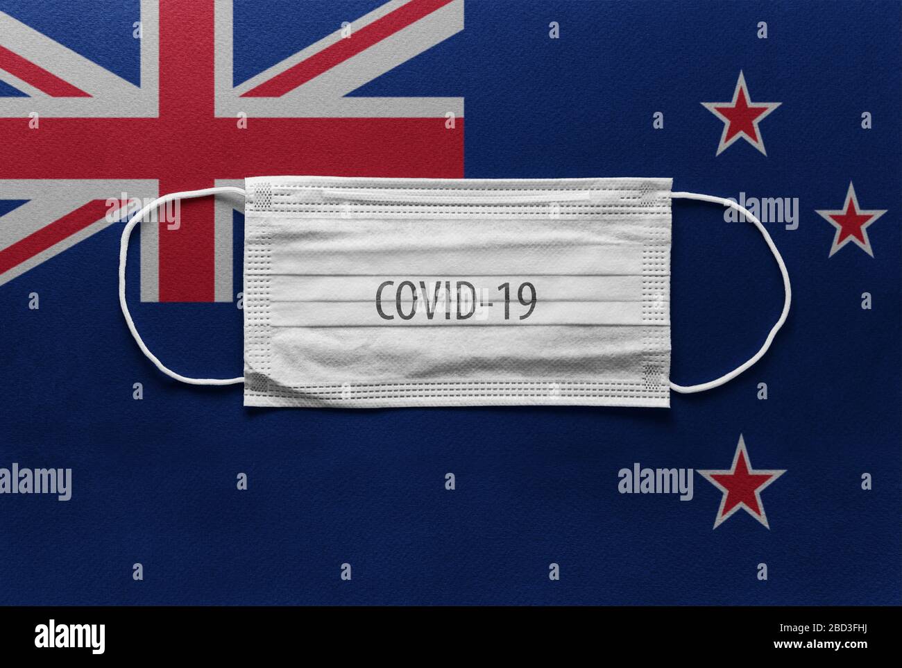 An individual face medical surgical mask on New Zeland national flag Background. Health mask. Protection against COVID-19 virus, influenza, SARS. Save Stock Photo