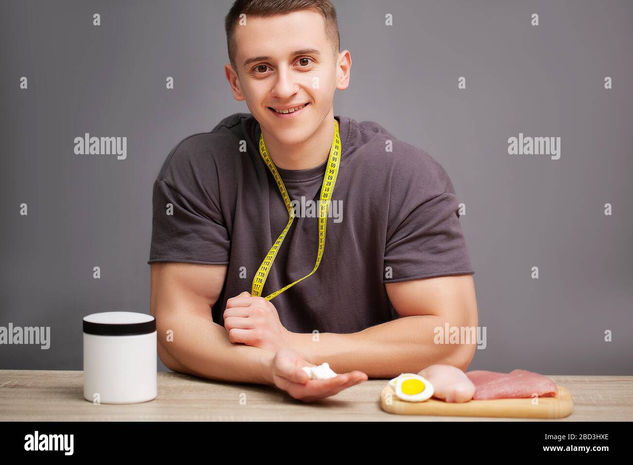 Trainer takes a pill of amino acids after training Stock Photo Alamy