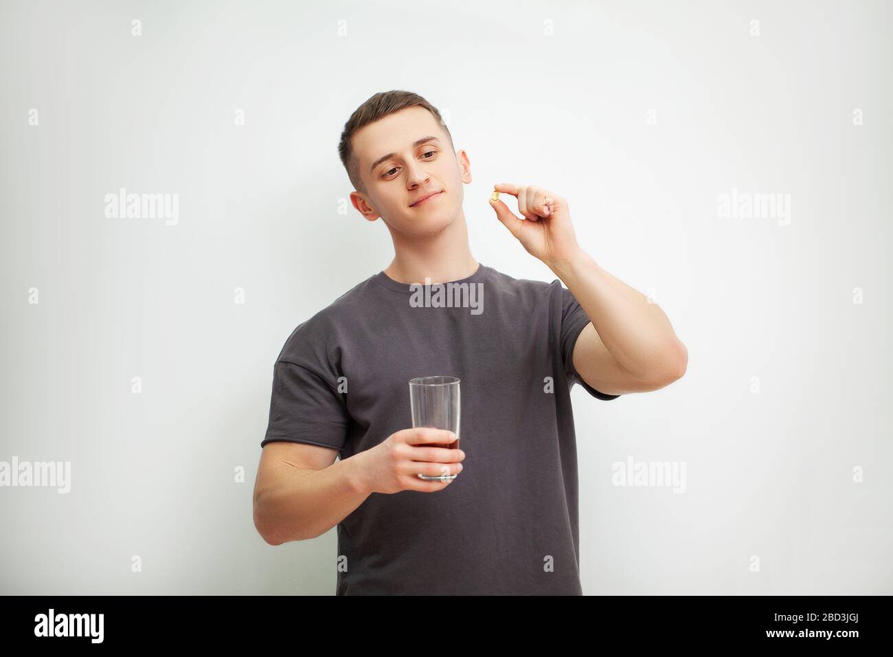 Trainer takes a pill of amino acids after training Stock Photo Alamy