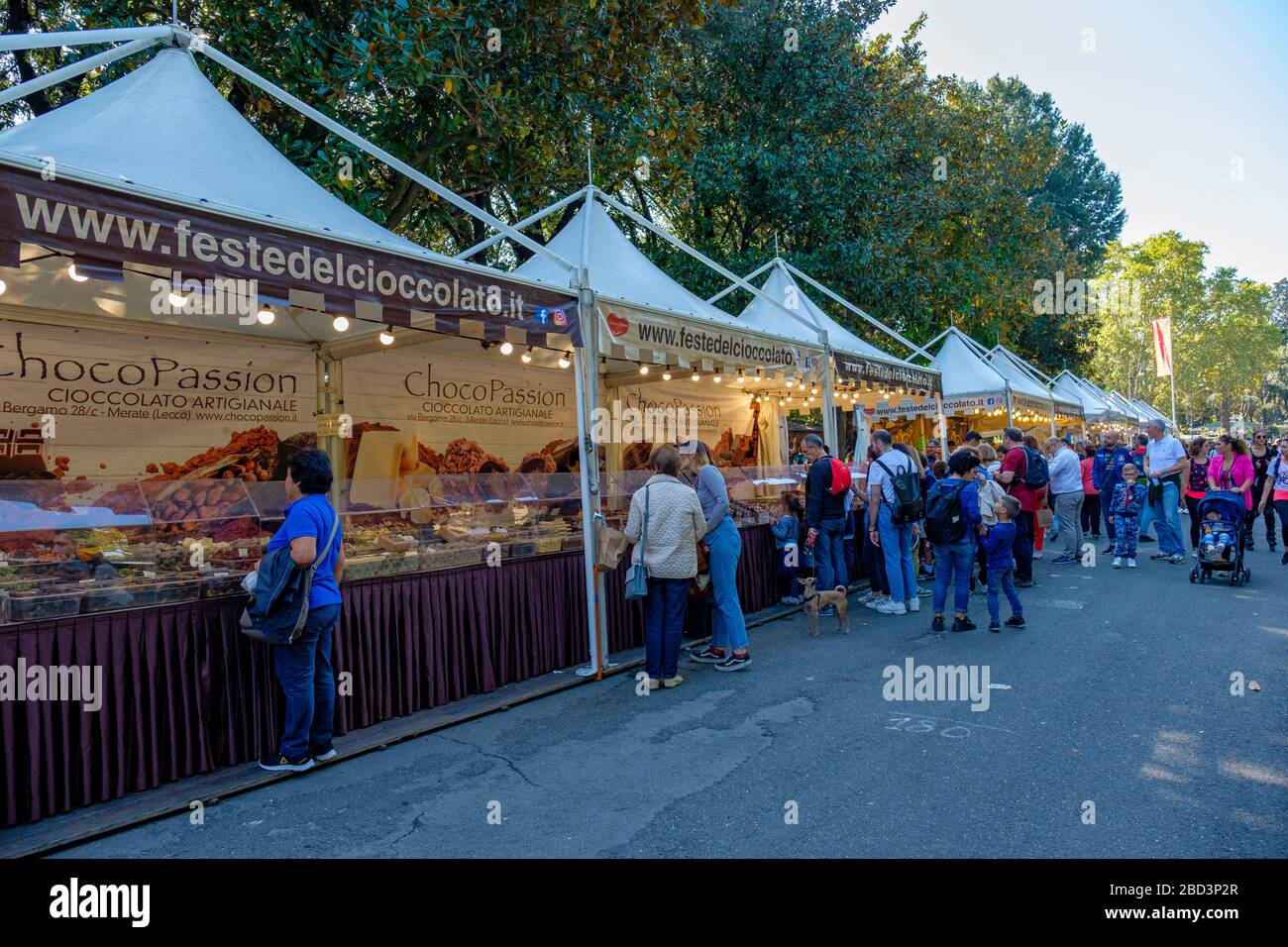 People buying chocolate in stands at a chocolate fair at Villa Borghese park, Rome, Italy. Stock Photo