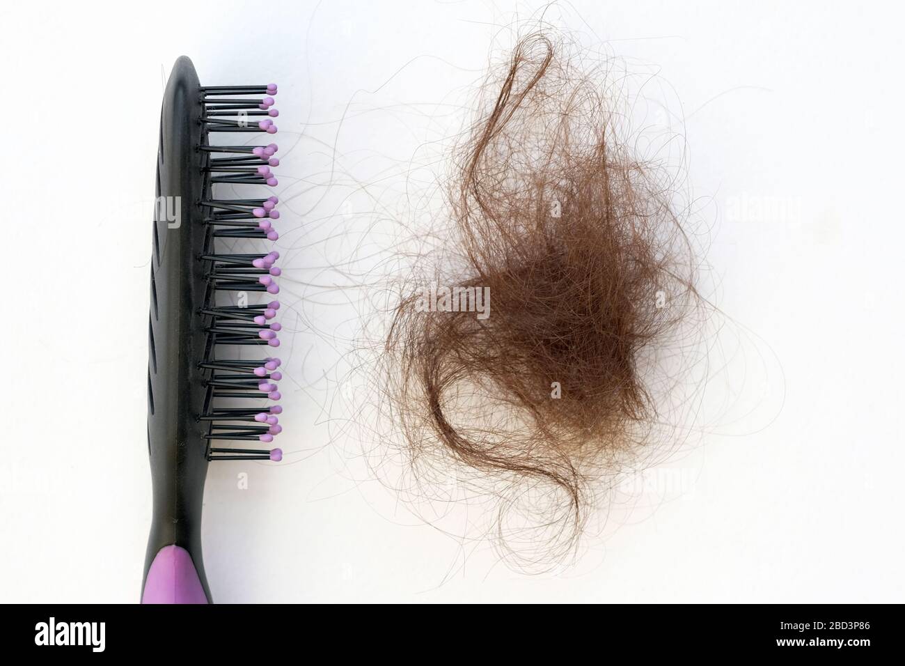 Black comb and a bundle of brown hair on a white background. Comb and  fallen combed hair top view. The problem of excessive hair loss, treatment  of al Stock Photo - Alamy