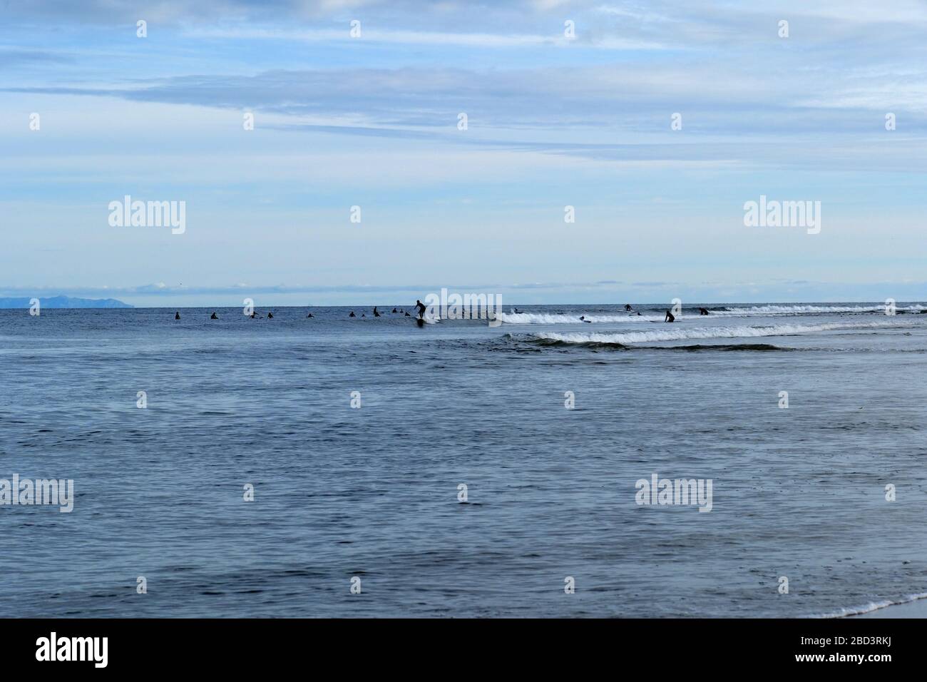 Surfers wait for a good wave out in the ocean at Surfrider Beach in Malibu California Stock Photo