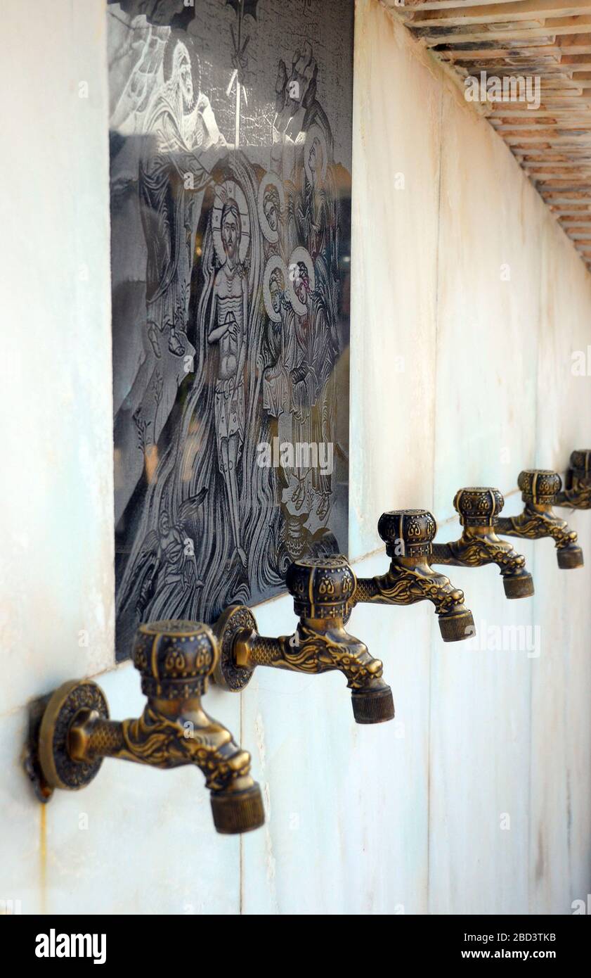 Drinking water taps for pilgrims at a greek monastry courtyard.Greece Stock Photo