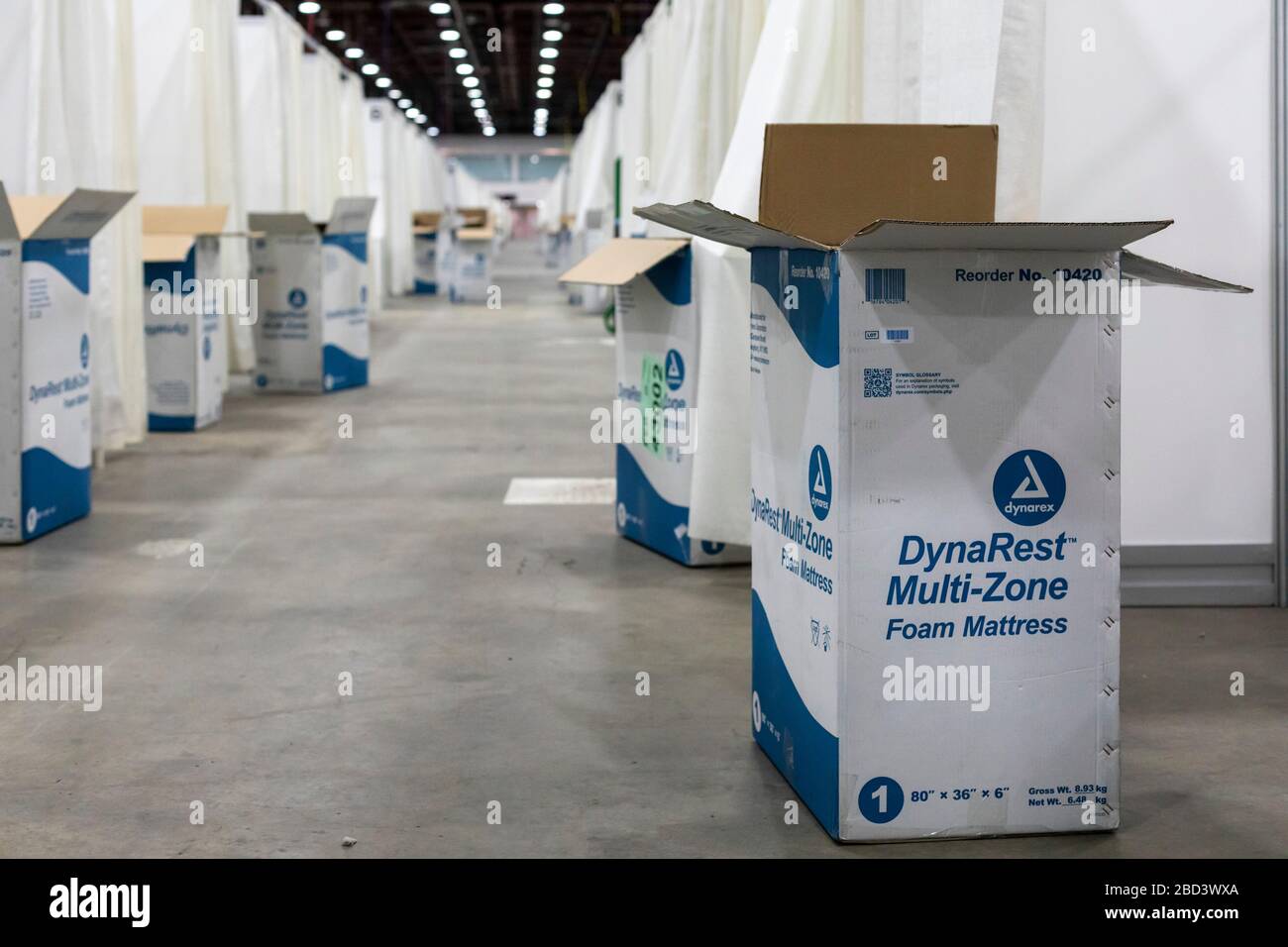 Detroit, Michigan, USA. 6th Apr, 2020. Workers construct an emergency field hospital at the TCF convention center. The 1,000-bed hospital will care for Covid-19 patients. Mattress boxes line the hall outside patient cubicles. Credit: Jim West/Alamy Live News Stock Photo