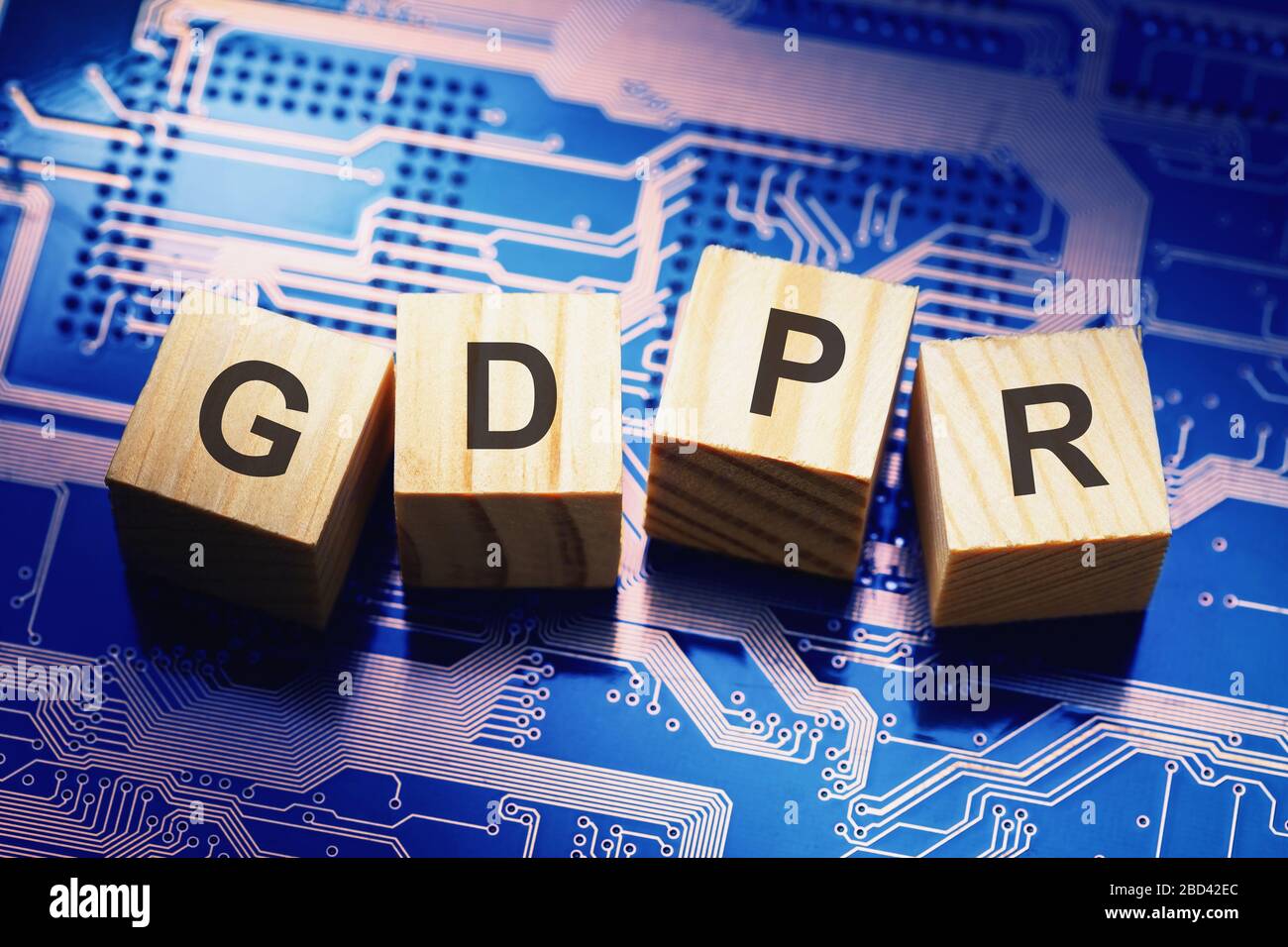 Wooden cubes with text on microcircuit background, symbolizing the EU General Data Protection Regulation or GDPR Stock Photo