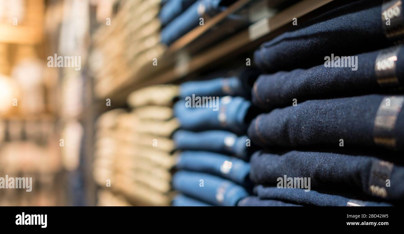 Display shelves with denim pants jeans trousers in clothing on the rack