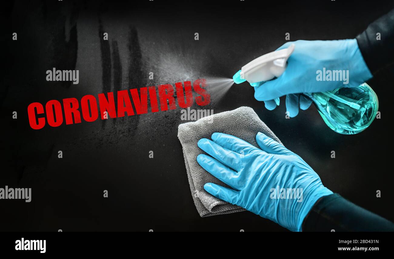Coronavirus disinfecting surfaces cleaning home cleaning spraying aways red text with sanitizing spray bottle against COVID-19 wearing blue gloves. Sanitize surface prevention. Stock Photo