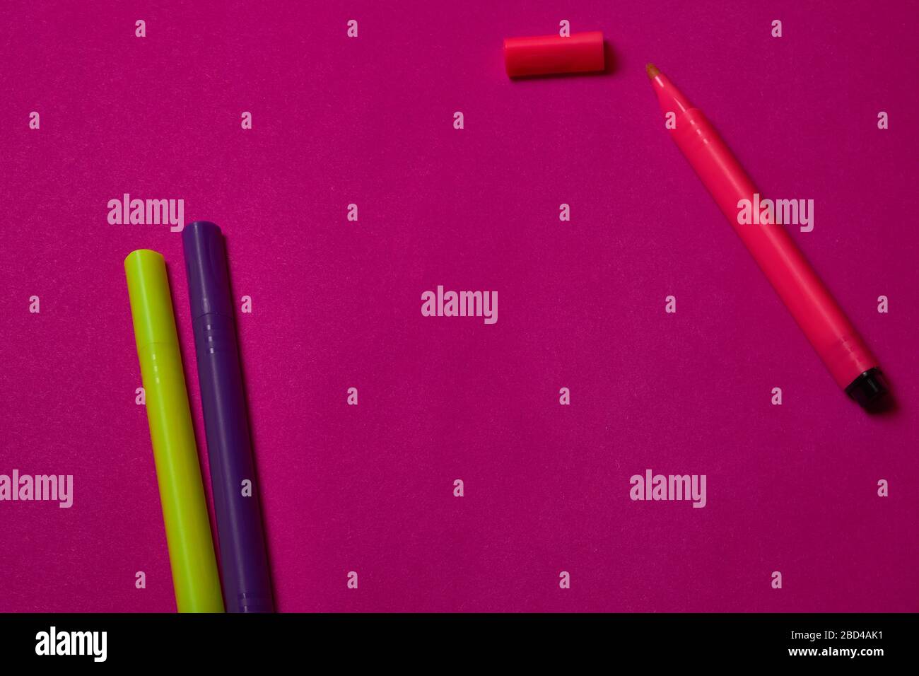 Multi colored felt tip pens at magenta background with copy space. Stock Photo