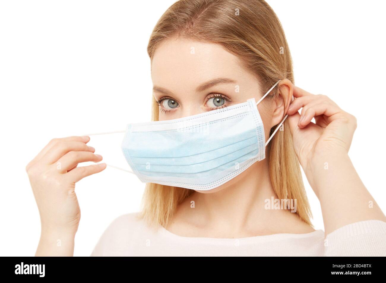 A blond woman put on a medical mask Stock Photo - Alamy