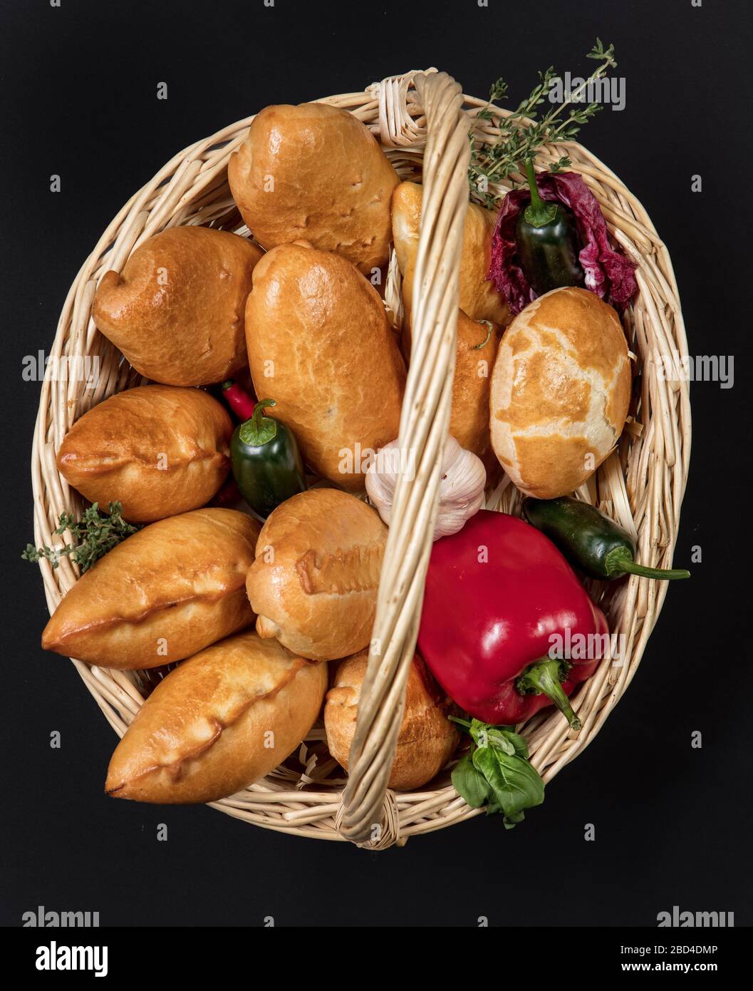 Pies with meat in the wicker basket on a black background Stock Photo