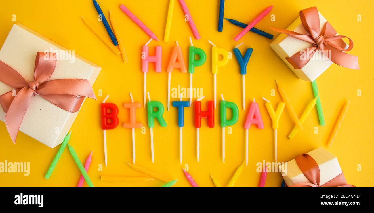 Happy Birthday candles on yellow background. Bright color wallpaper