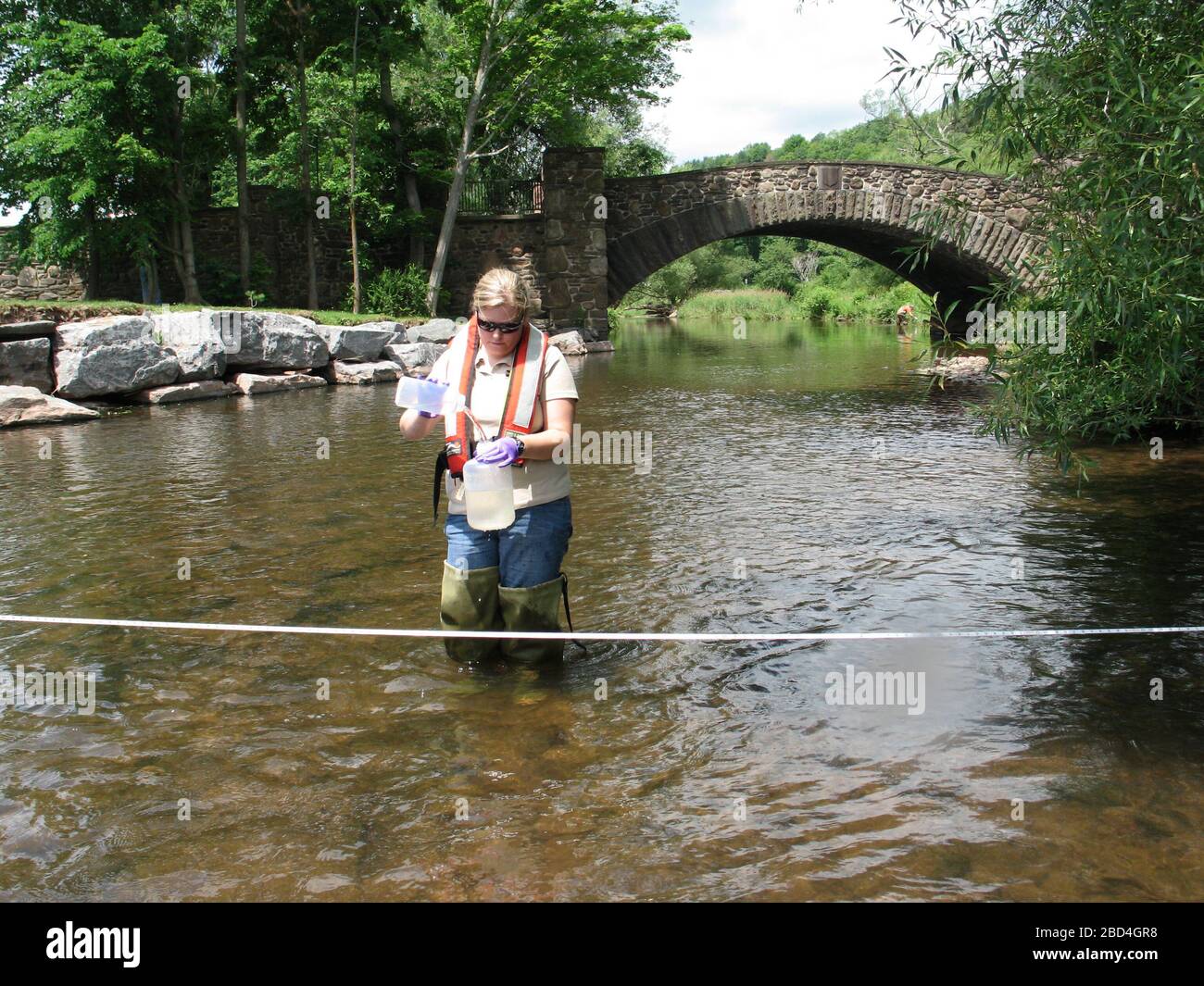 USGS hydrologist collecting a water quality sample from a NY stream ca. June 2010 Stock Photo