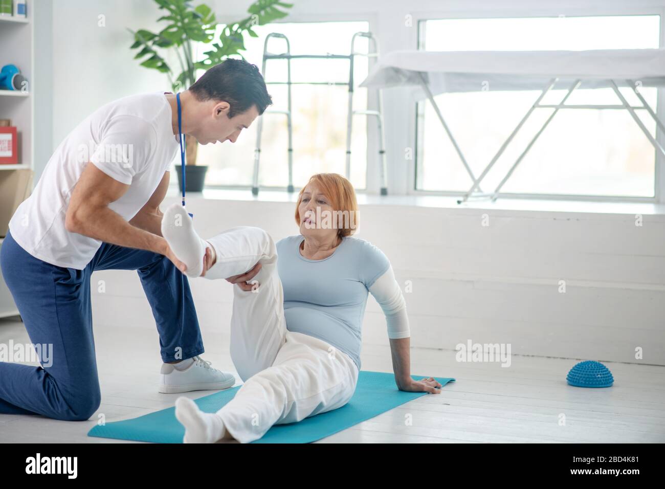 Nice pleasant woman having her leg supported Stock Photo
