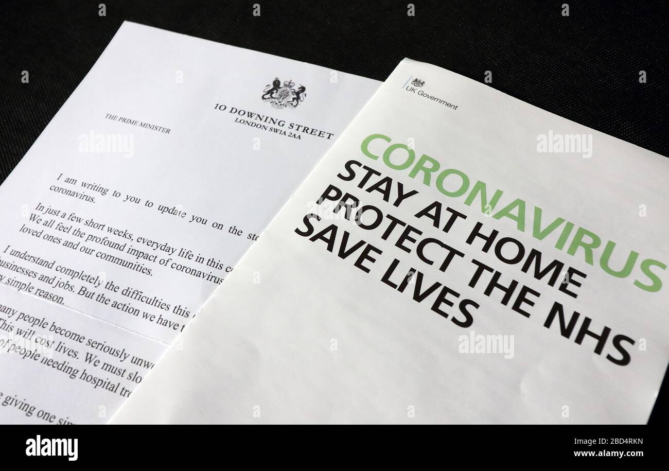 In this photo illustration, a letter from the British Prime Minster and HM Government Coronavirus leaflet are seen on display.A coronavirus letter from the British Prime Minister Boris Johnson to be sent to every UK household urging the public to stay home. Around 30 million UK households will receive the Covid-19 letter, along with a leaflet about Coronavirus symptoms, guidelines and awareness. Stock Photo