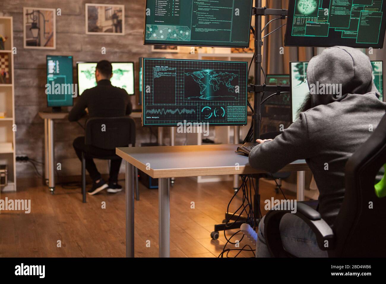 Back view of two hacker working together to create chaos in the world ...