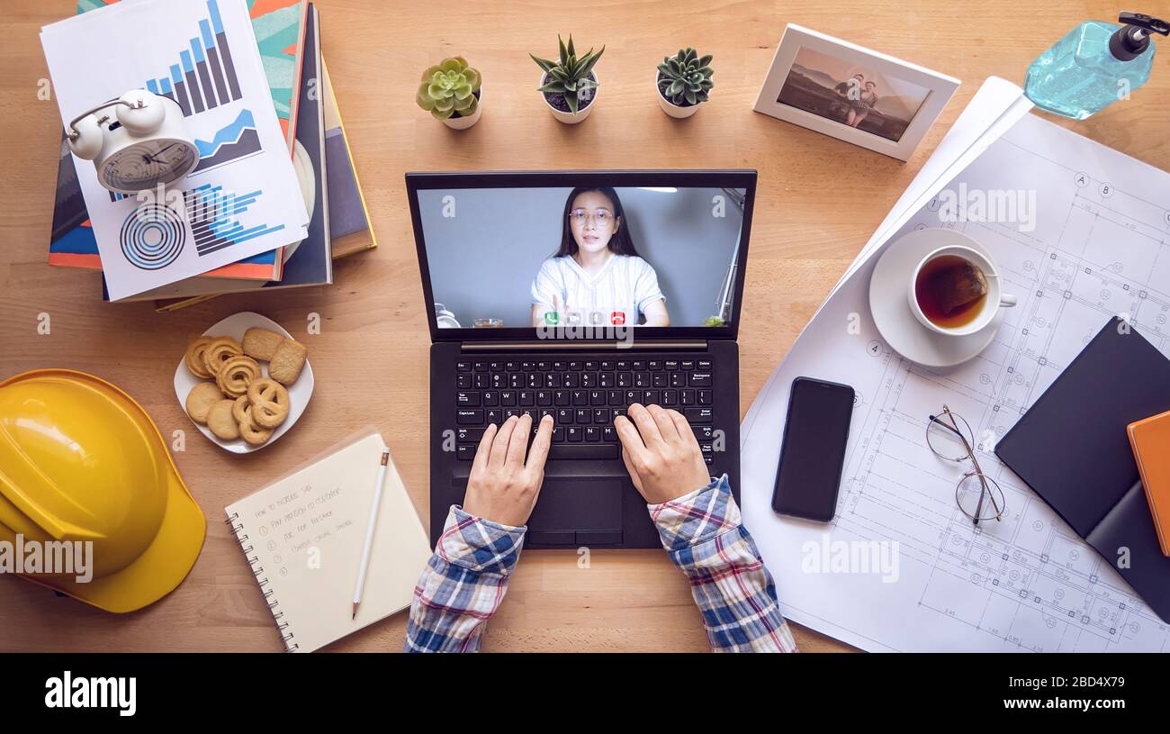 work from home. boss making video conference to order work with employee via laptop computer during home isolation to avoid spreading illness transmis Stock Photo