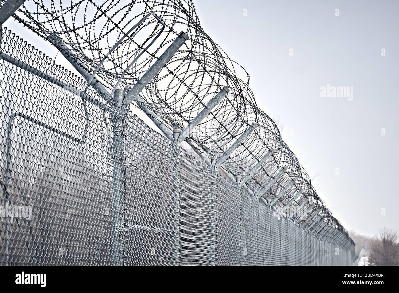 Border fence with barbed wire. Closing for quarantine. Maximum Security Detention Facility. Stock Photo