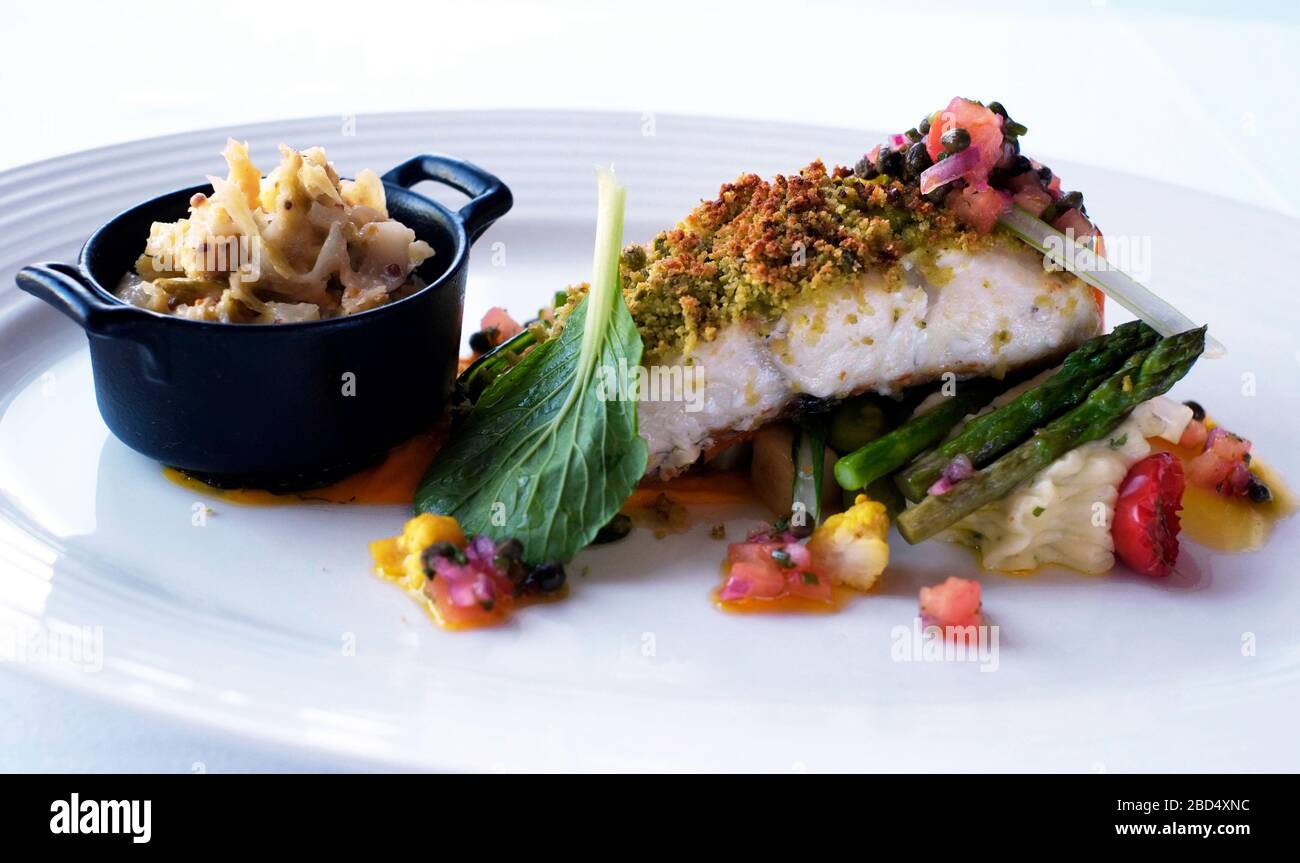Baked hake with a Pistachio & Herb Crust, Creamed Savoy Cabbage and Glazed Ardtornish vegetables at Kilcamb Lodge on Scotland's Loch Sunart Stock Photo