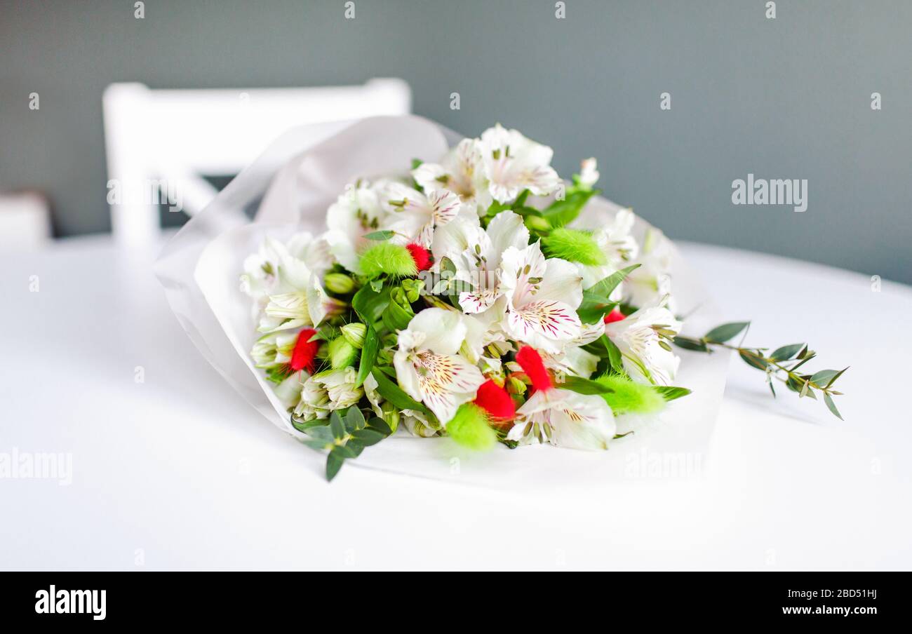 Bouquet of white alstroemeria flowers in lying on a white round table Stock Photo