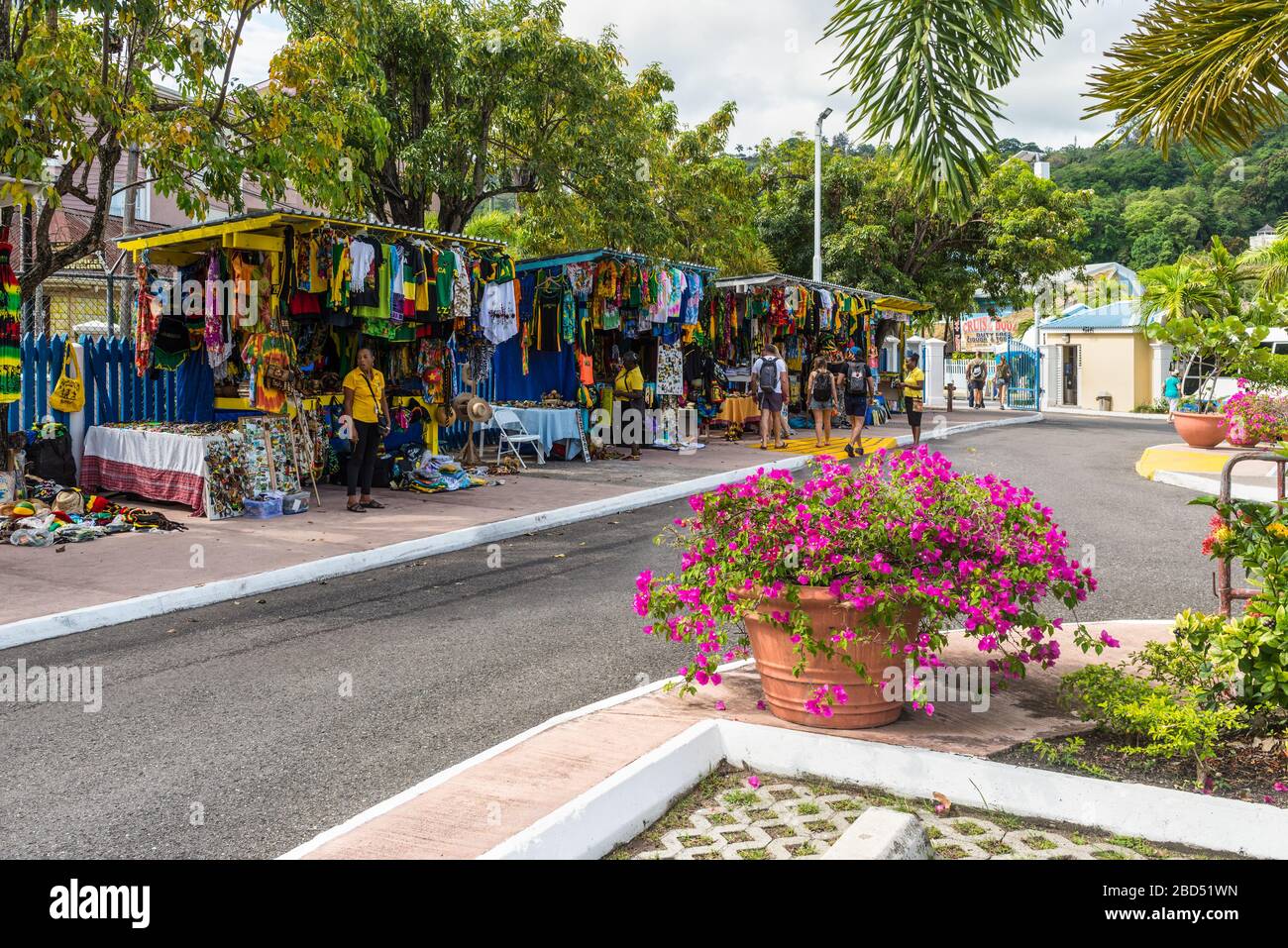Ocho Rios, Jamaica - April 22, 2019: Souvenir street market in the tropical Caribbean island of Ocho Rios, Jamaica. Flowerbed in the foreground. Stock Photo