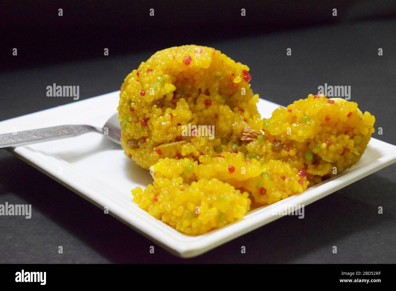 Indian Sweet Moti Choor Laddu in White Plate Top View on Black Background Close-Up Stock Photograph Image Stock Photo