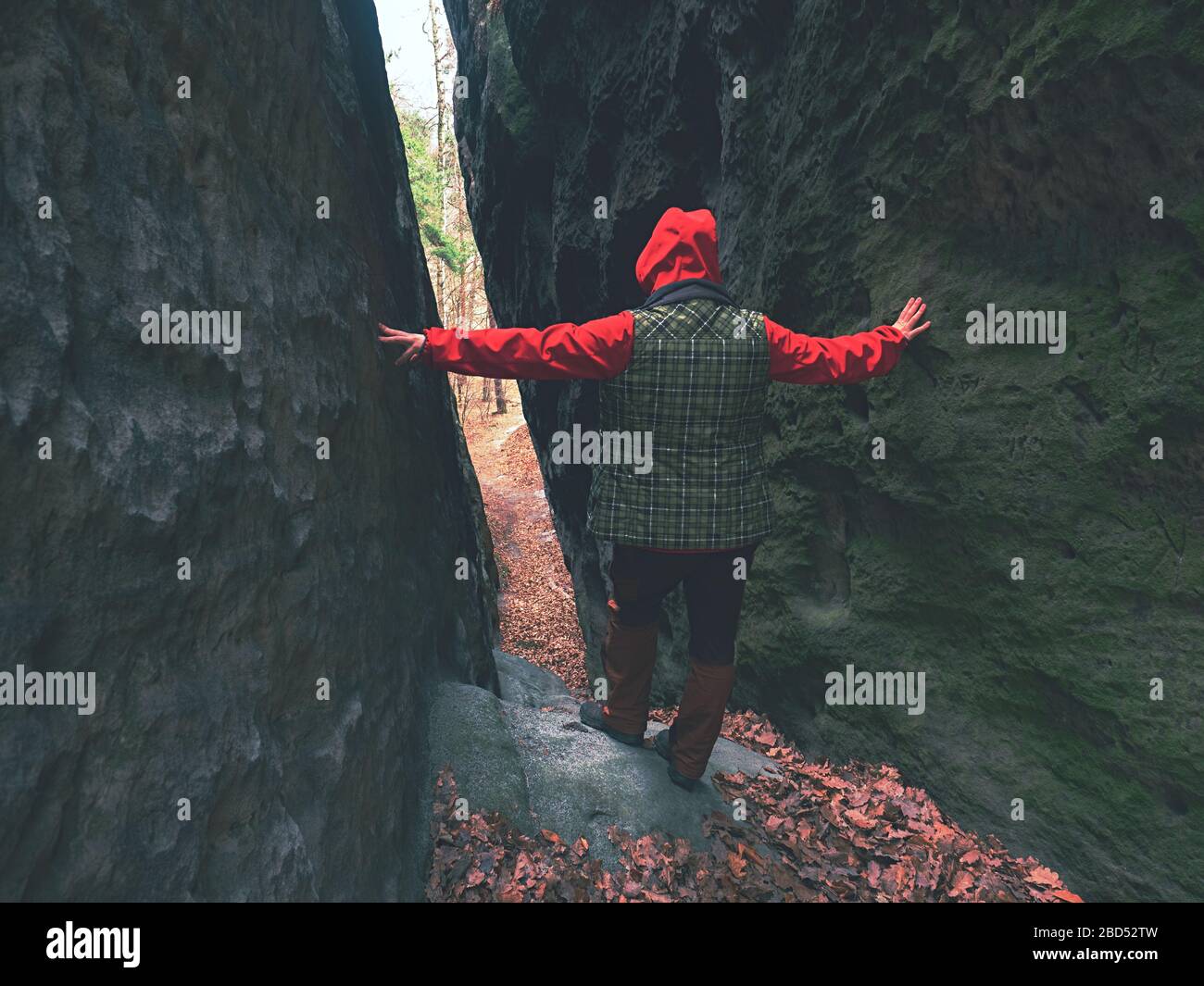 woman goes through thin pass between sandstone rocks Stock Photo - Alamy