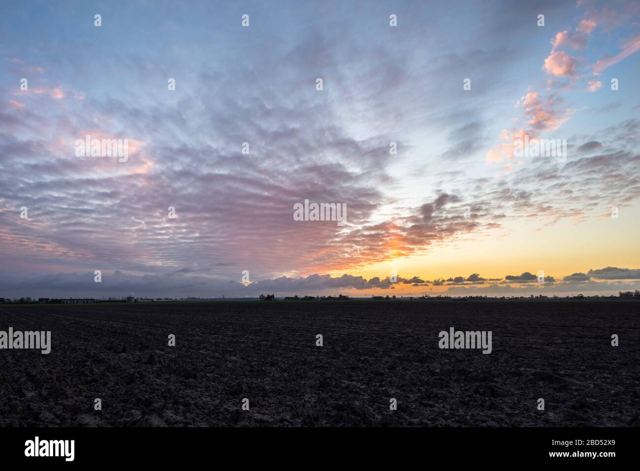 Stunning colors in the sky over the wide open and flat landscape of the province of South Holland (dutch: Zuid-Holland) Stock Photo