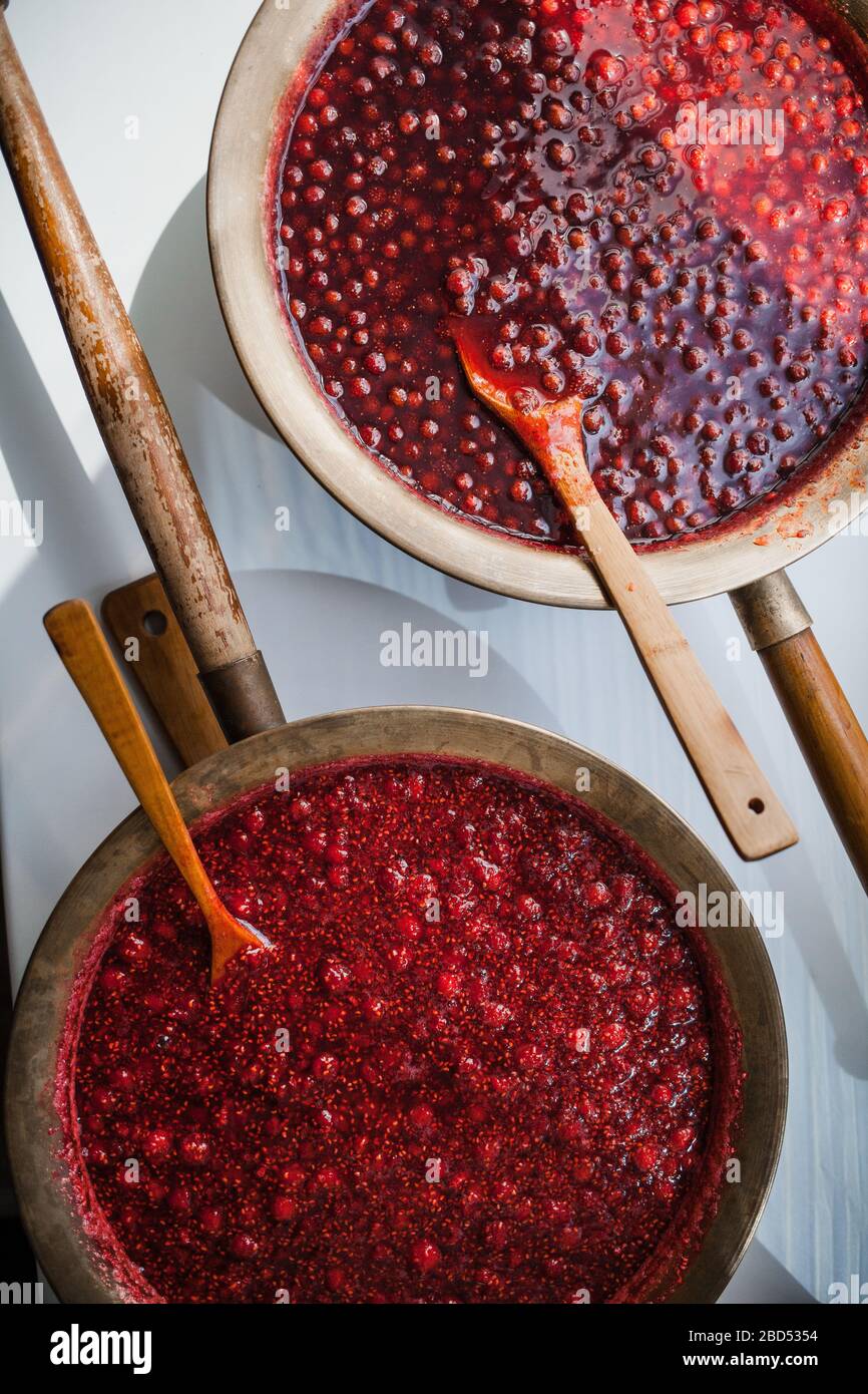 two basins of homemade preparations with strawberry and raspberry jam ...