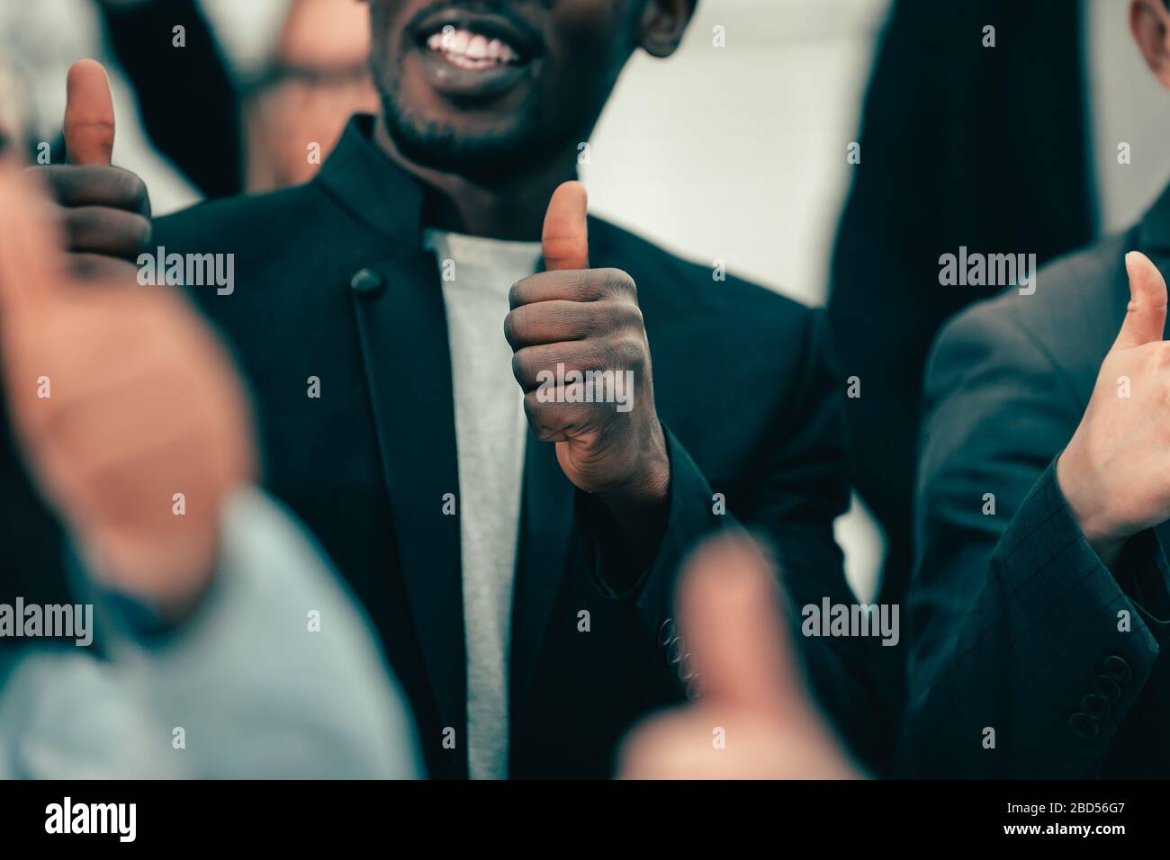 close up. young business people showing thumbs up Stock Photo - Alamy