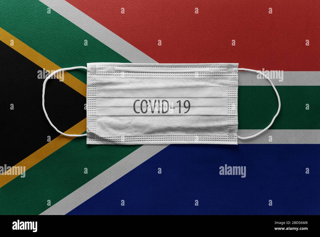 An individual face medical surgical mask on South Africa National Flag Background. Health mask. Protection against COVID-19 virus, influenza, SARS. Sa Stock Photo