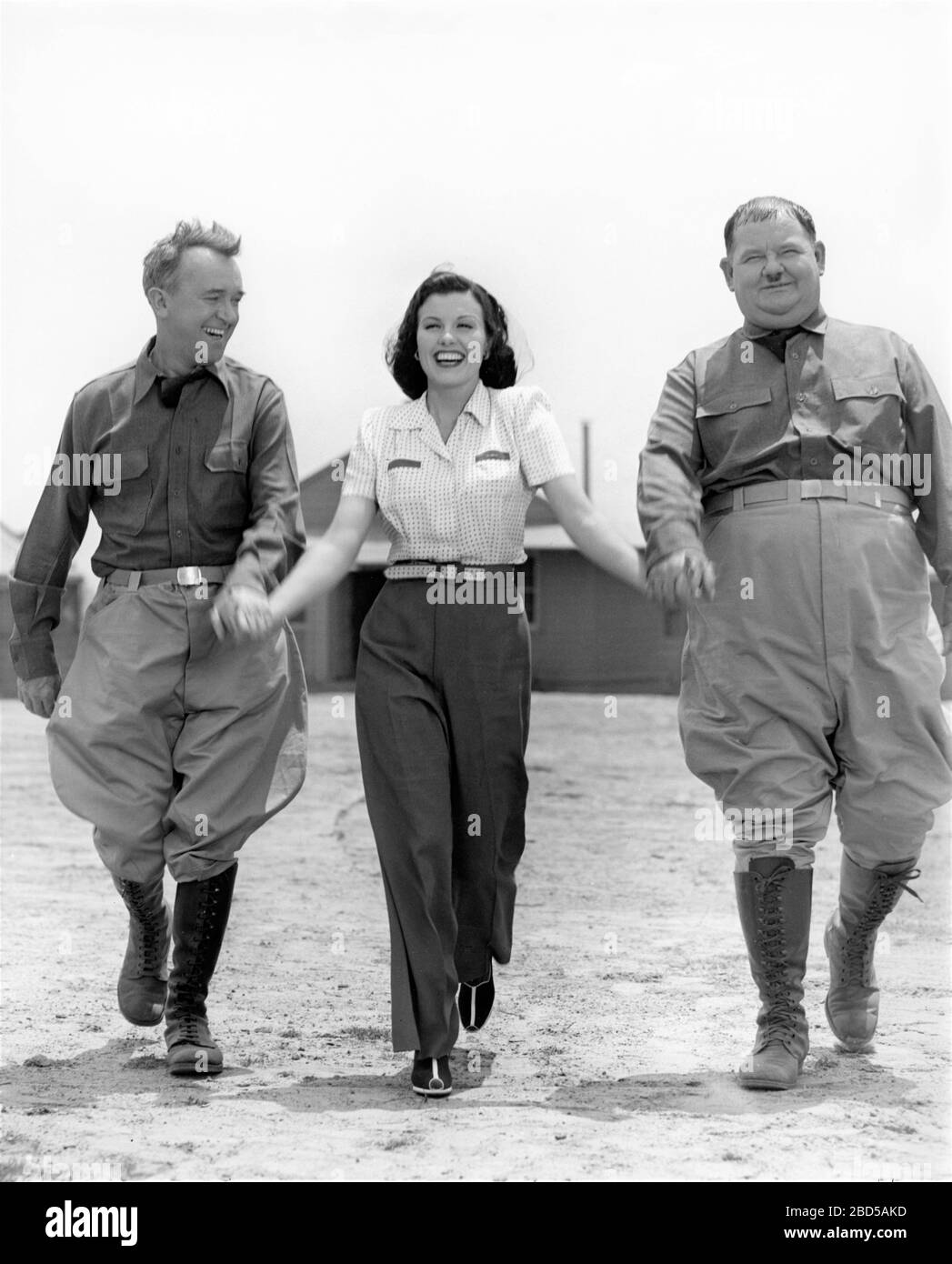 STAN LAUREL and OLIVER HARDY on set candid with SHEILA RYAN during filming of GREAT GUNS 1941 director MONTY BANKS Laurel and Hardy Feature Productions / Twentieth Century Fox Stock Photo