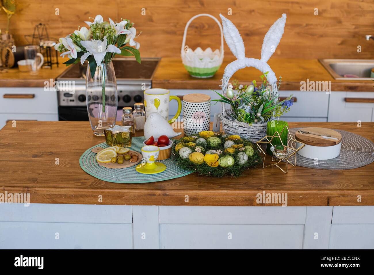 Beautiful spring Easter kitchen counter. flowers and decorative eggs. Vase of lilies on the counter. Stock Photo