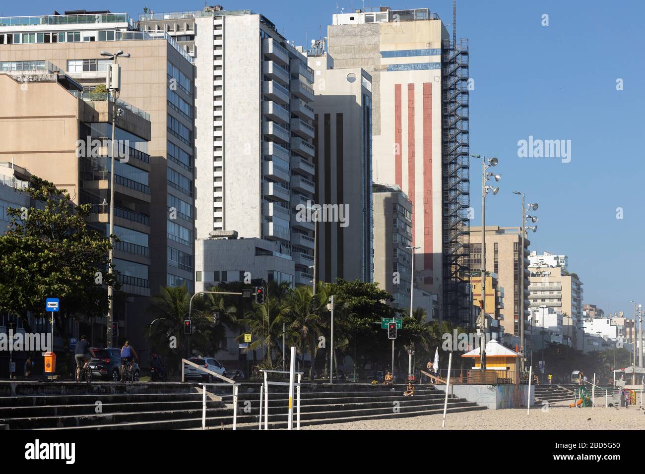High rise buildings on Leblon boulevard and beach during the COVID-19 Corona virus outbreak on a sunny midday with only a few people and little traffi Stock Photo