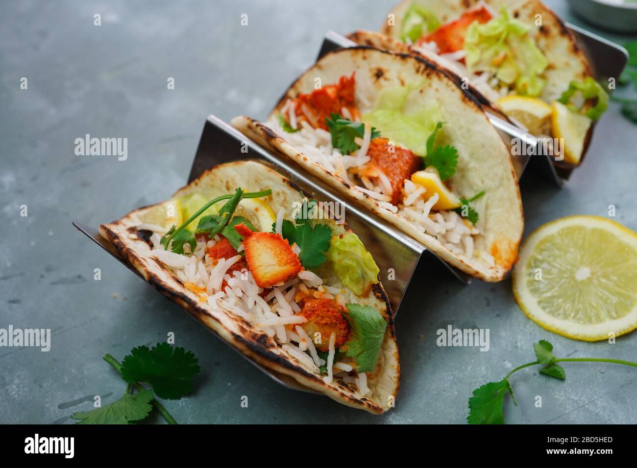 Homemade Chicken Tikka Tacos served in a metal Taco stand, selective focus Stock Photo