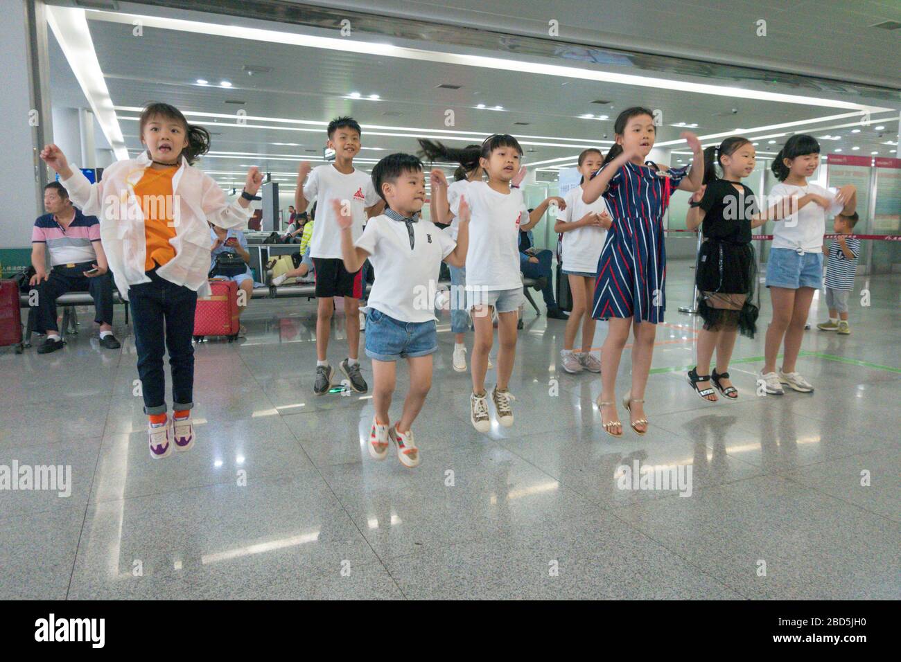childen performing song and dance routine to music, departure lounge, Quanzhou airport, China Stock Photo