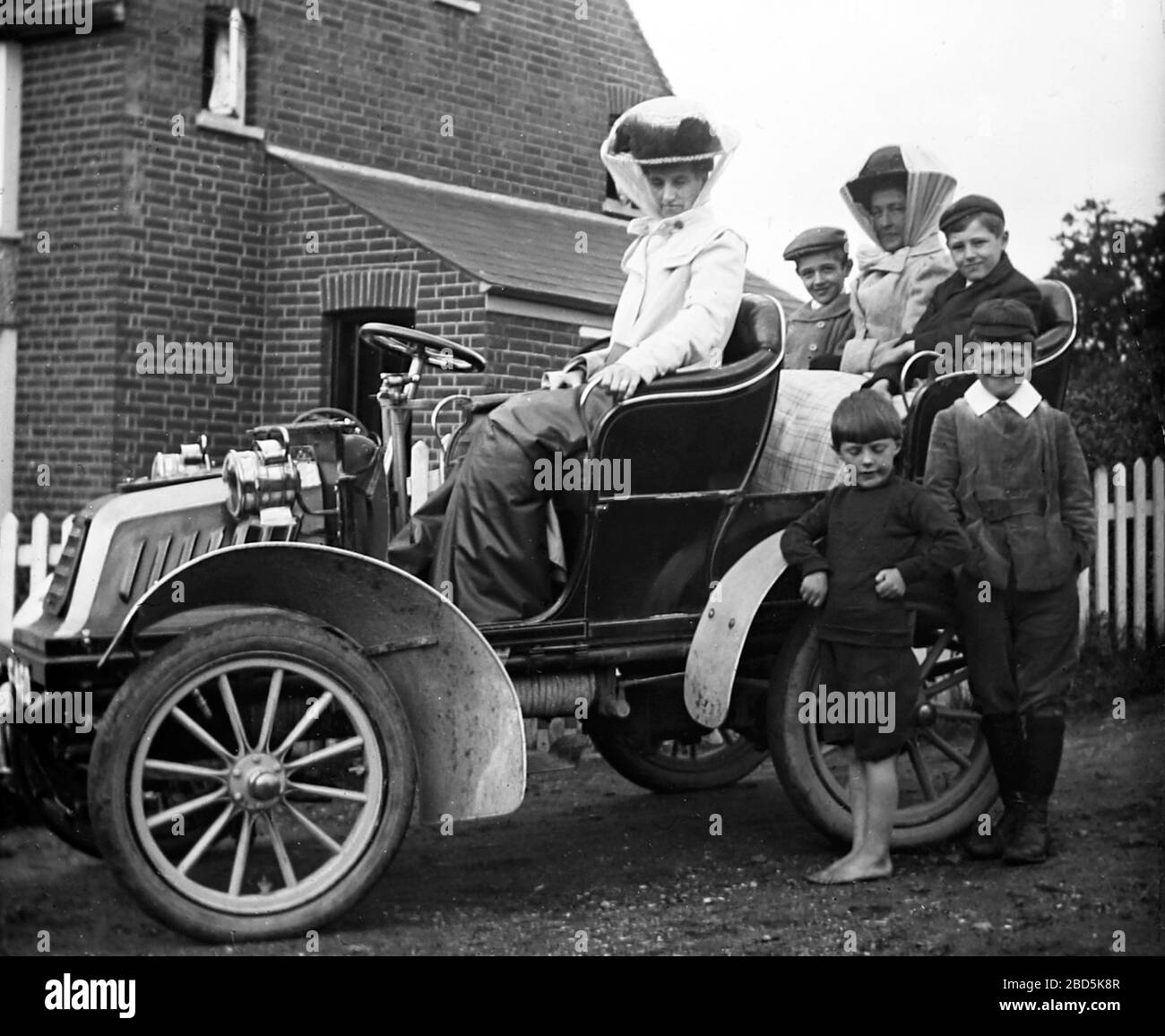 Veteran car and children posing for a photo, early 1900s Stock Photo
