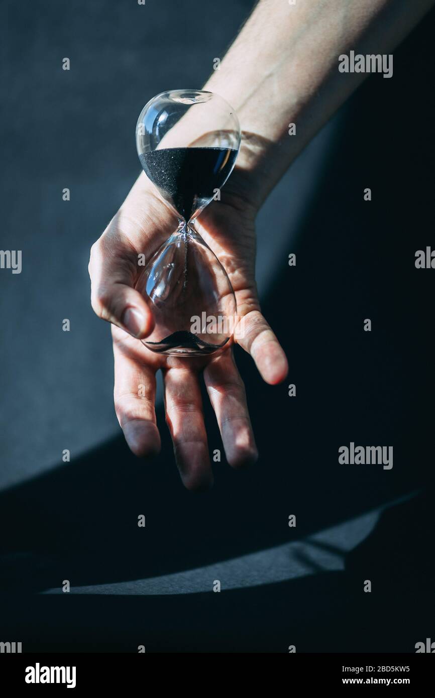 Male hand holds hourglass Stock Photo