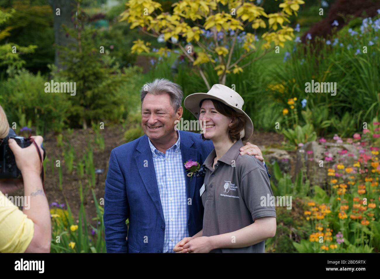 Alan Titchmarsh posing for a photo with a female RHS Gardener at a flower show to celebrate 70 years of RHS Garden Harlow Carr, Harrogate, UK. Stock Photo