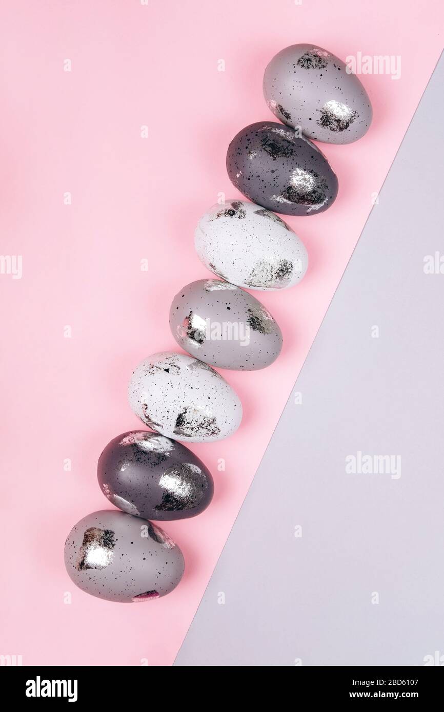 Easter eggs in two rows on grey and pink background. copy space. Stock Photo