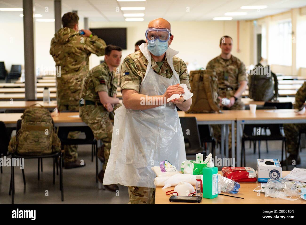 Members of the British Army learn how to apply PPE during training to