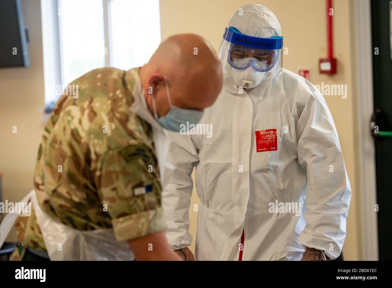 Members of the British Army learn how to apply PPE during training to support the Welsh Ambulance Service NHS Trust (WAST) in the battle against COVID-19 at the Sennybridge Training Camp in Mid Wales. Stock Photo