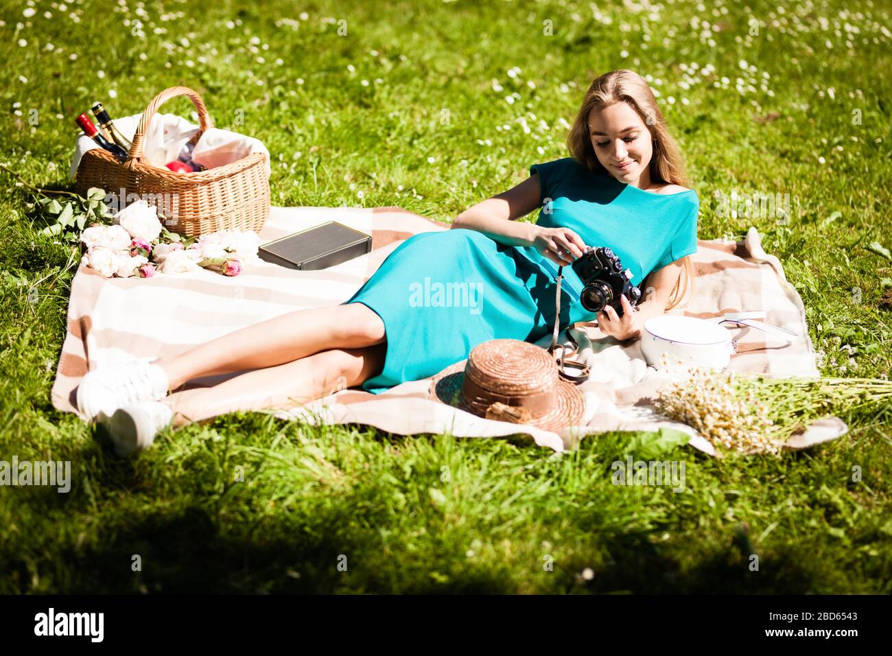 Portrait of happy young woman having rest on picnic in park Stock Photo